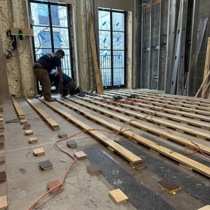 Installers laying wood sleepers to level a subfloor