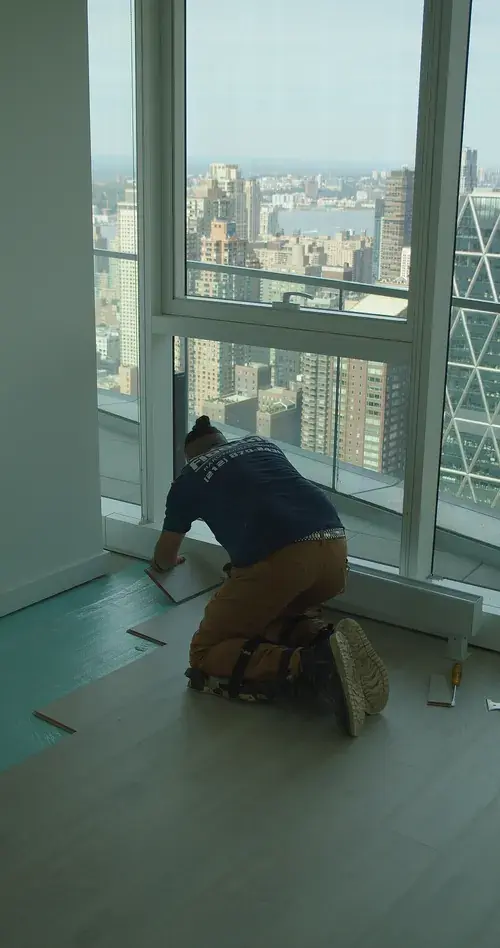 Nolan installer fitting plank flooring in a New York high-rise