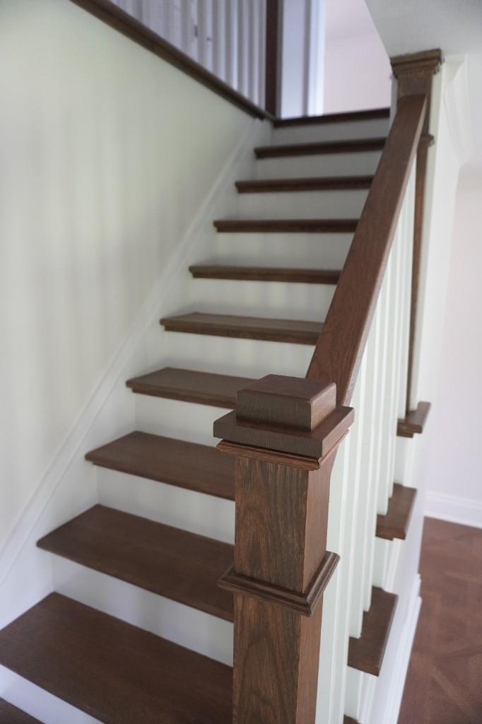 Hardwood staircase with dark treads, white risers and matching newel post