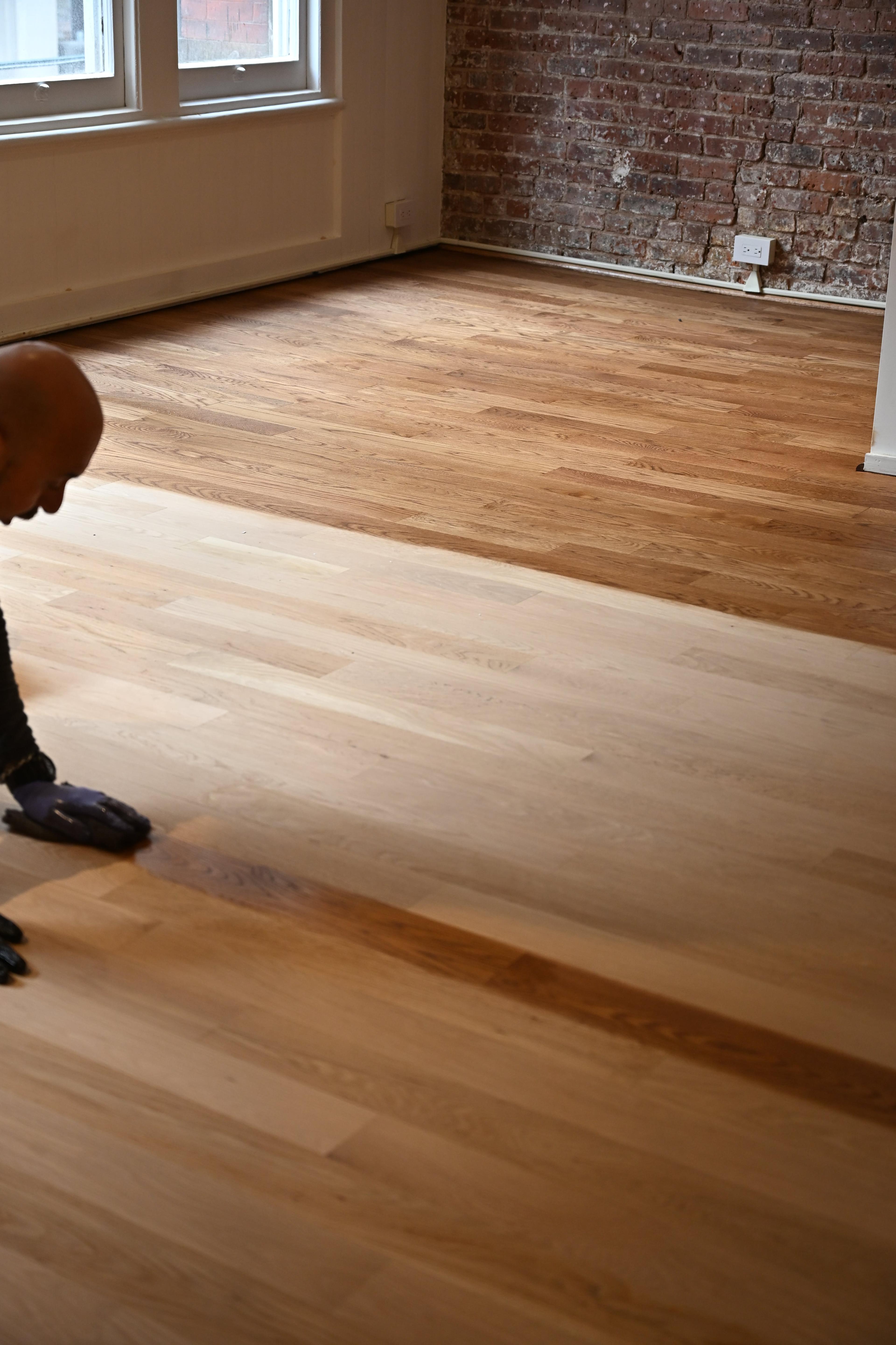 Dark stain being applied to hardwood at 158 Franklin St