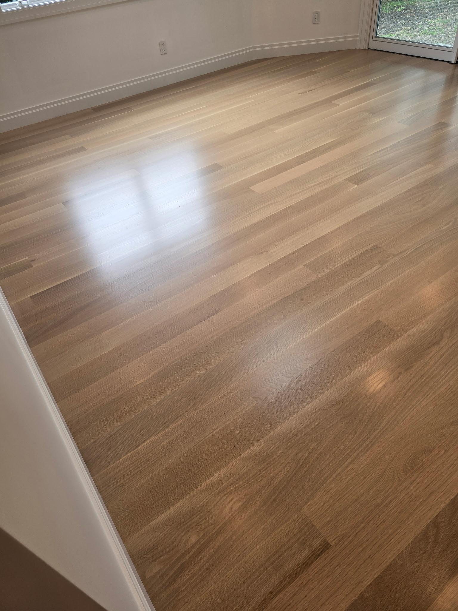 Finished light hardwood room at Roslyn Heights