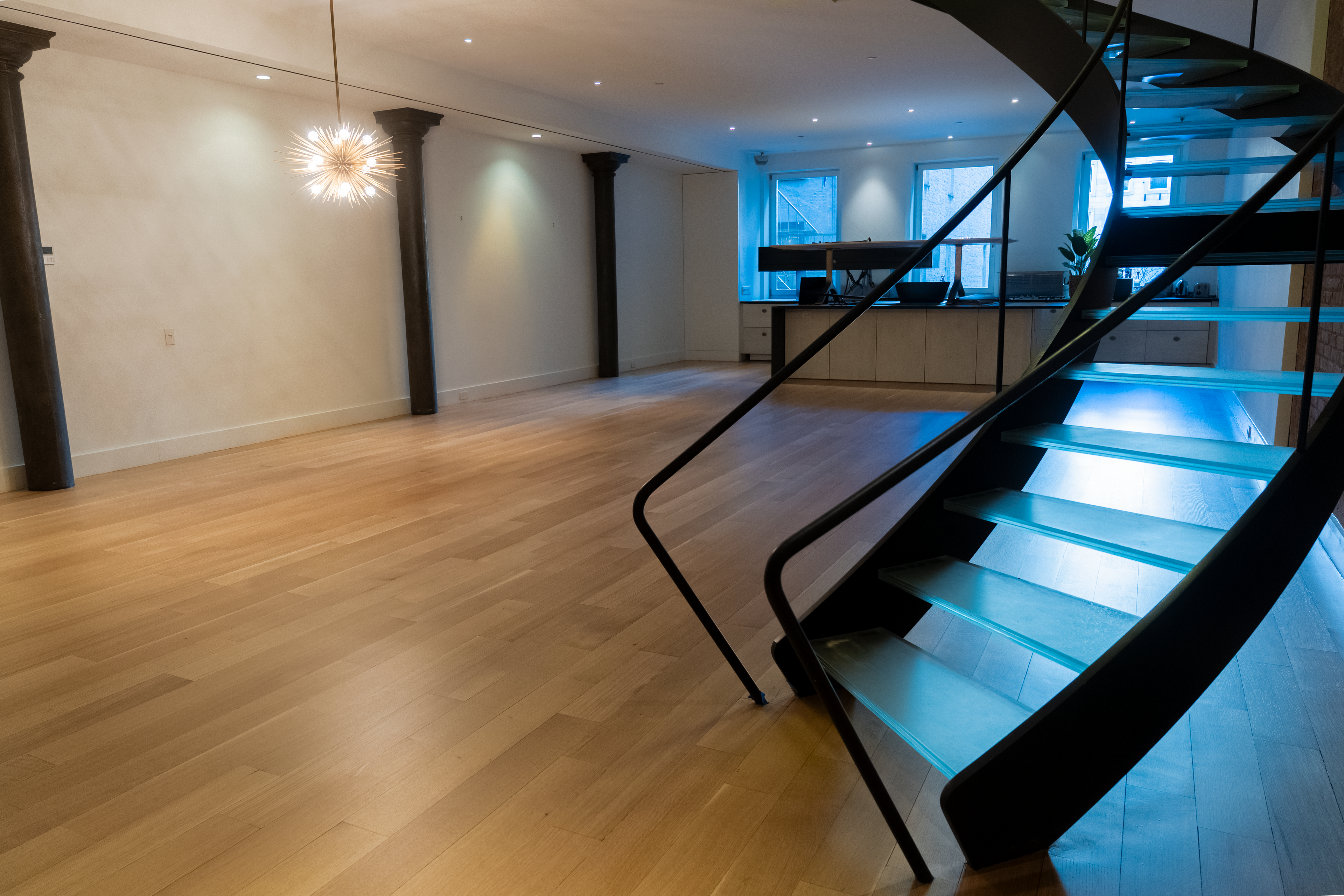 Loft floor with the spiral stair in the foreground at Wooster St